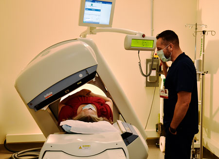 Male Nuclear Medicine Technician assisting patient with testing