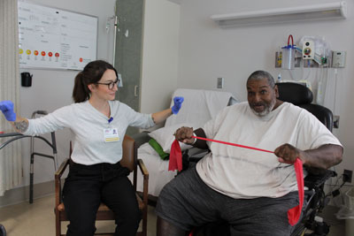 Nurse assisting patient with strengthing,