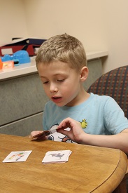 small boy reading cards